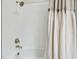 A modern shower stall with a curtain showcases contemporary faucets and gleaming white tiling at 11146 Rustic Timber Loop, San Antonio, FL 33576