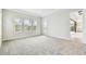 Spacious bedroom with neutral paint, plush carpeting, and natural light from windows, leading to the ensuite at 11146 Rustic Timber Loop, San Antonio, FL 33576