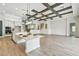 Spacious open floor plan with an island kitchen, white cabinetry, and hardwood floors throughout the living area at 11146 Rustic Timber Loop, San Antonio, FL 33576