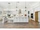 Bright kitchen features white cabinets, stainless steel appliances, pendant lighting, and a spacious island at 11146 Rustic Timber Loop, San Antonio, FL 33576
