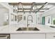 Kitchen island featuring a stainless steel sink, white countertops, and an open floorplan to the living area at 11146 Rustic Timber Loop, San Antonio, FL 33576