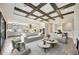 Wide open living space with kitchen, dining, and living room featuring wood beams, white furniture, and hardwood floors at 11146 Rustic Timber Loop, San Antonio, FL 33576