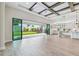 Open living area with modern kitchen, wood beam ceiling, and sliding glass doors to the landscaped backyard at 11146 Rustic Timber Loop, San Antonio, FL 33576