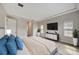 Spacious bedroom features a tray ceiling, neutral walls, a mounted TV, and an ensuite bathroom at 11146 Rustic Timber Loop, San Antonio, FL 33576