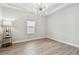 A modern office space features wood floors, a modern chandelier, large window and ample light at 11146 Rustic Timber Loop, San Antonio, FL 33576