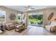 Bright living room with a neutral color palette, large windows, and a sliding glass door to the outdoor space at 11393 Velvet Apricot Dr, Land O Lakes, FL 34638