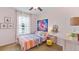 Cozy bedroom featuring a ceiling fan, brightly colored bedspread, and eclectic decorative accents at 11412 Velvet Apricot Dr, Land O Lakes, FL 34638