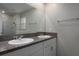 Bathroom features a double vanity with granite countertops, large mirror, and neutral wall color at 11704 Castine St, New Port Richey, FL 34654