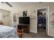 Bedroom featuring a bed, TV, shelves, and doorways leading to an en-suite bathroom and closet at 11704 Castine St, New Port Richey, FL 34654