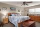 Bright bedroom features a blue and white patterned bedspread, natural light, and wooden furniture at 11704 Castine St, New Port Richey, FL 34654