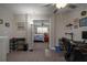 Bright home office featuring modern desk setup, neutral walls, and carpet flooring leading into a bedroom at 11704 Castine St, New Port Richey, FL 34654