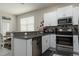 Modern kitchen with stainless steel appliances, granite countertops, and white cabinets, perfect for cooking at 11704 Castine St, New Port Richey, FL 34654