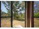 View from the screened patio showcasing a serene backyard and distant buildings at 11704 Castine St, New Port Richey, FL 34654