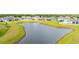 Aerial view of the home, surrounded by a scenic lake and well-maintained landscaping at 12916 Brookside Moss Dr, Riverview, FL 33579