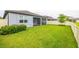 View of the backyard featuring a manicured lawn, partial view of the screened-in patio, and privacy fence at 12916 Brookside Moss Dr, Riverview, FL 33579