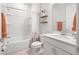 Clean, bright bathroom featuring a shower-tub combo and decorative shelving at 12916 Brookside Moss Dr, Riverview, FL 33579