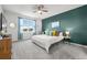 Bedroom with white comforter and teal accent wall and curtains, and a ceiling fan at 12916 Brookside Moss Dr, Riverview, FL 33579