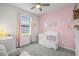 Charming Bedroom with pastel accents, soft natural light and cute baby furniture at 12916 Brookside Moss Dr, Riverview, FL 33579
