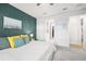 Bedroom with white comforter and teal accent wall and curtains, and neutral colored walls at 12916 Brookside Moss Dr, Riverview, FL 33579