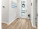 Bright foyer featuring wood-look flooring, a decorative wreath, and views of the front door at 12916 Brookside Moss Dr, Riverview, FL 33579
