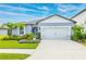 Well-manicured front yard highlighting lush landscaping and a two-car garage, complementing the home's exterior at 12916 Brookside Moss Dr, Riverview, FL 33579