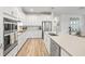 Bright kitchen features white cabinets, stainless steel appliances, an island, and hardwood flooring at 12916 Brookside Moss Dr, Riverview, FL 33579