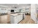 Bright open concept featuring a kitchen island, hardwood flooring, and an open living space at 12916 Brookside Moss Dr, Riverview, FL 33579