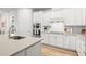 Kitchen features white cabinets, stainless steel appliances, hardwood flooring, and a white subway tile backsplash at 12916 Brookside Moss Dr, Riverview, FL 33579