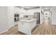 Bright kitchen features white cabinets, stainless steel appliances, an island, and hardwood flooring at 12916 Brookside Moss Dr, Riverview, FL 33579