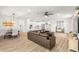 Open-concept living area with modern light fixtures, views of the dining area and a brown leather sofa at 12916 Brookside Moss Dr, Riverview, FL 33579
