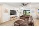 Spacious living room featuring a brown leather sofa, entertainment center, and a view to the backyard at 12916 Brookside Moss Dr, Riverview, FL 33579