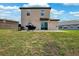 View of a home's backyard with grill, sliding glass doors, and green grass at 14100 Holly Hammock Ln, Brooksville, FL 34613