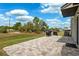 Large backyard patio featuring stone pavers, a grill, and scenic backyard views at 14100 Holly Hammock Ln, Brooksville, FL 34613