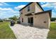 Spacious backyard patio with stone pavers, grill, and sliding glass door entrance at 14100 Holly Hammock Ln, Brooksville, FL 34613