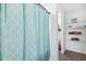 Bright bathroom featuring a patterned shower curtain and organized shelving at 14100 Holly Hammock Ln, Brooksville, FL 34613