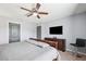 Spacious bedroom with a ceiling fan, dresser, and television, offering ample space and entertainment at 14100 Holly Hammock Ln, Brooksville, FL 34613
