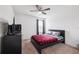 Well-lit bedroom featuring a ceiling fan, carpet flooring, a window, and a TV set at 14100 Holly Hammock Ln, Brooksville, FL 34613