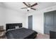 Clean bedroom with a dark bed set, carpet flooring, and a ceiling fan, offering simple comfort at 14100 Holly Hammock Ln, Brooksville, FL 34613