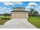 Inviting two-story home featuring a well-manicured lawn and a two-car garage at 14100 Holly Hammock Ln, Brooksville, FL 34613