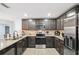 Modern kitchen with granite countertops, stainless steel appliances, and dark wood cabinetry at 14100 Holly Hammock Ln, Brooksville, FL 34613