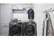 Well-equipped laundry room with modern washer and dryer set, cabinets, and hanging rack at 14100 Holly Hammock Ln, Brooksville, FL 34613