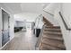 Bright entryway leading to living area, showcasing hardwood floors, plush seating, and staircase at 14100 Holly Hammock Ln, Brooksville, FL 34613