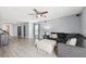 Spacious living room featuring gray walls, plush sectional sofa, and modern ceiling fan at 14100 Holly Hammock Ln, Brooksville, FL 34613
