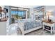 Bedroom boasts a comfortable bed, seaside decor, and sliding glass doors leading to a balcony with water views at 1460 Gulf Blvd # 509, Clearwater Beach, FL 33767