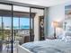 Charming bedroom boasts of a balcony with clear water views and city views in the distance at 1460 Gulf Blvd # 509, Clearwater Beach, FL 33767