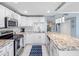 Well-lit kitchen with white cabinets, granite countertops, and stainless steel appliances at 1460 Gulf Blvd # 509, Clearwater Beach, FL 33767