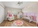 bedroom with wood floors, crib, closet, and toy storage at 14910 Par Club Cir, Tampa, FL 33618