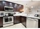 Modern kitchen features stainless steel appliances, white countertops, and dark cabinets at 14910 Par Club Cir, Tampa, FL 33618