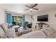 Living room with outside views, wood floors, neutral paint, ceiling fan and grey sectional sofa at 14910 Par Club Cir, Tampa, FL 33618