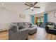Bright living room with view of the outside, wood floors, neutral paint, ceiling fan and grey sectional sofa at 14910 Par Club Cir, Tampa, FL 33618